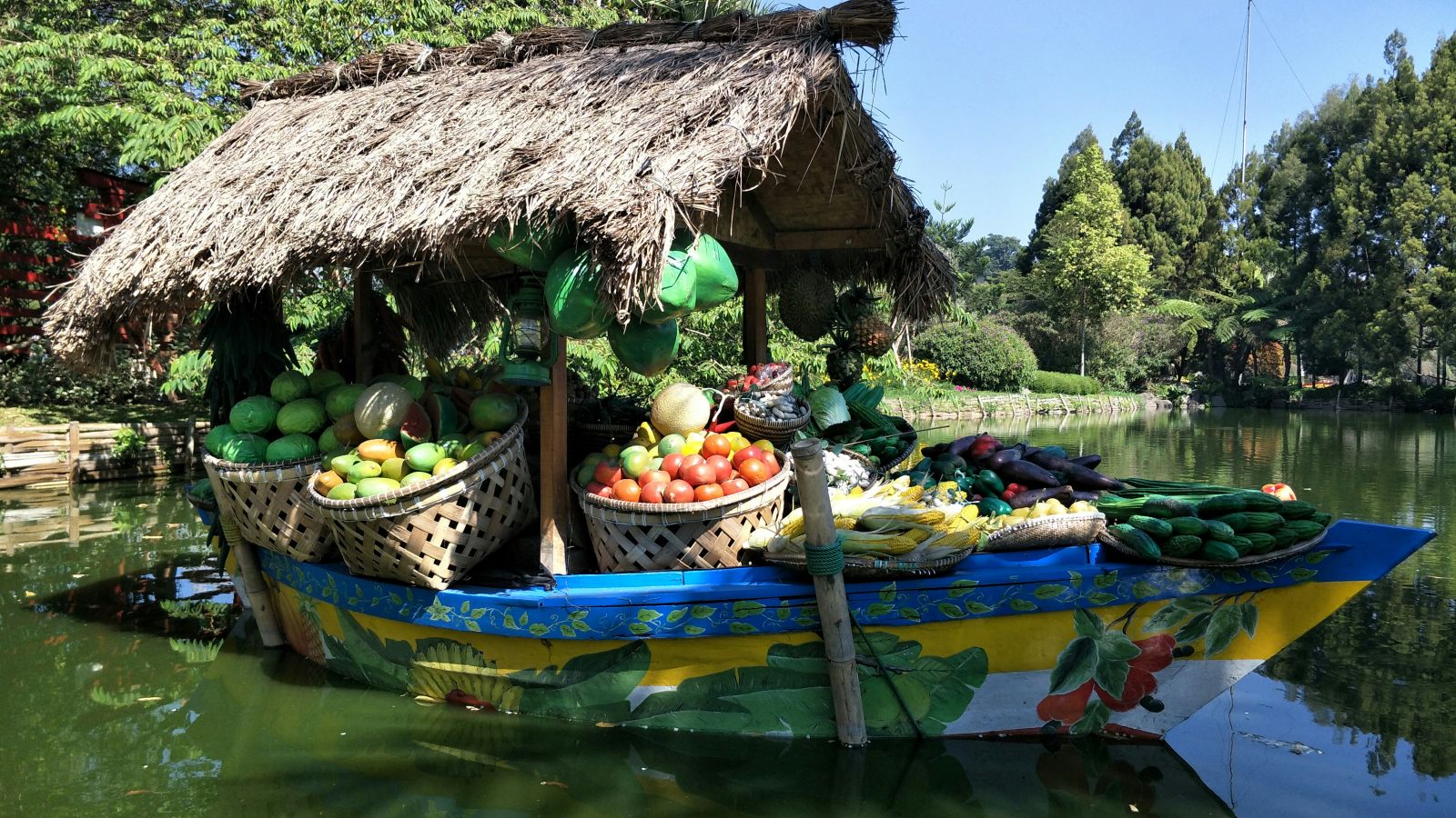 a boat filled with fruits and and veggies travelling on a waterbody