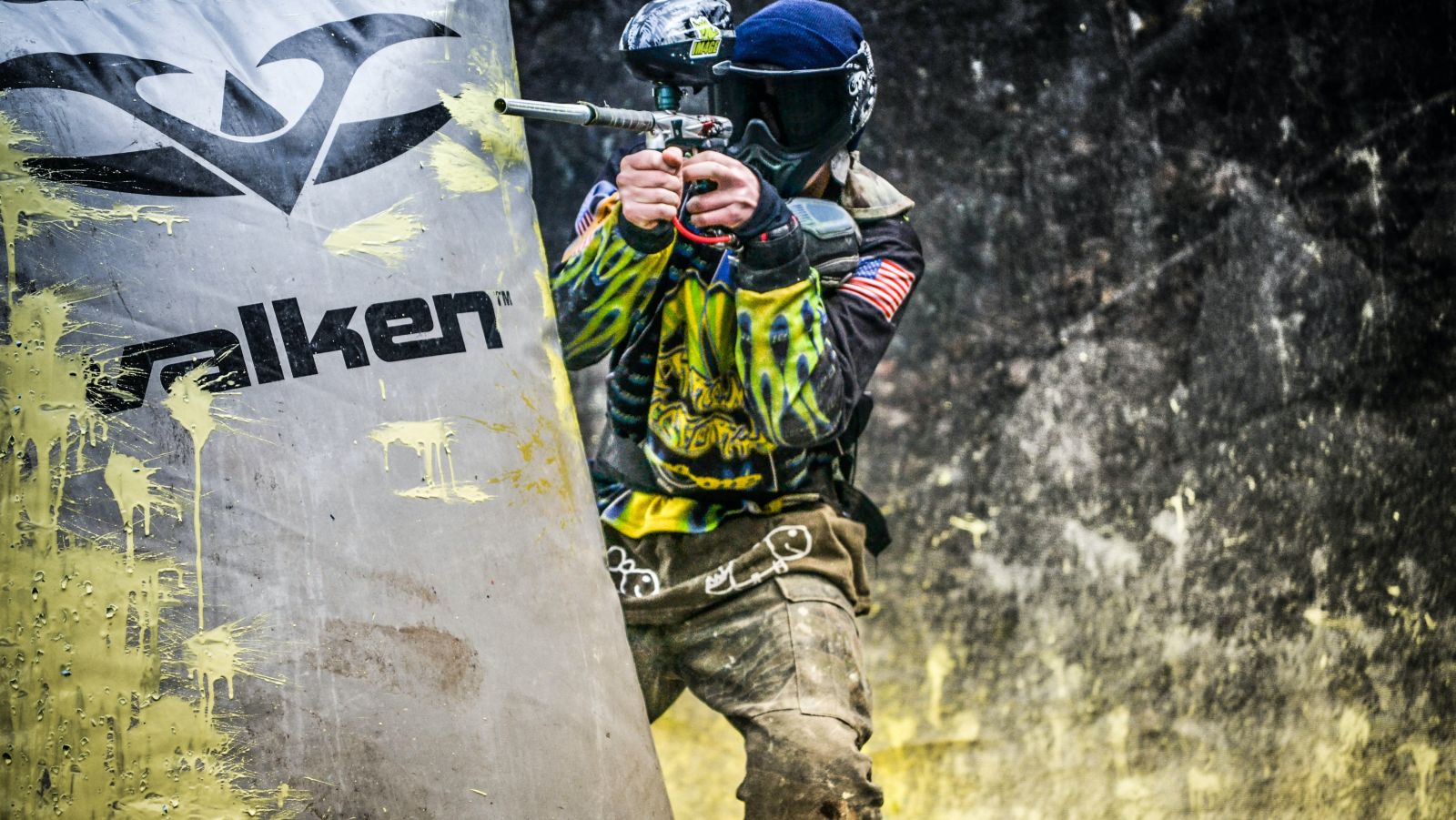 A person playing paintball aiming at someone 