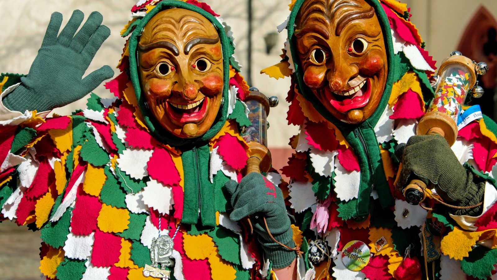 two people wearing mask and costumes during a parade