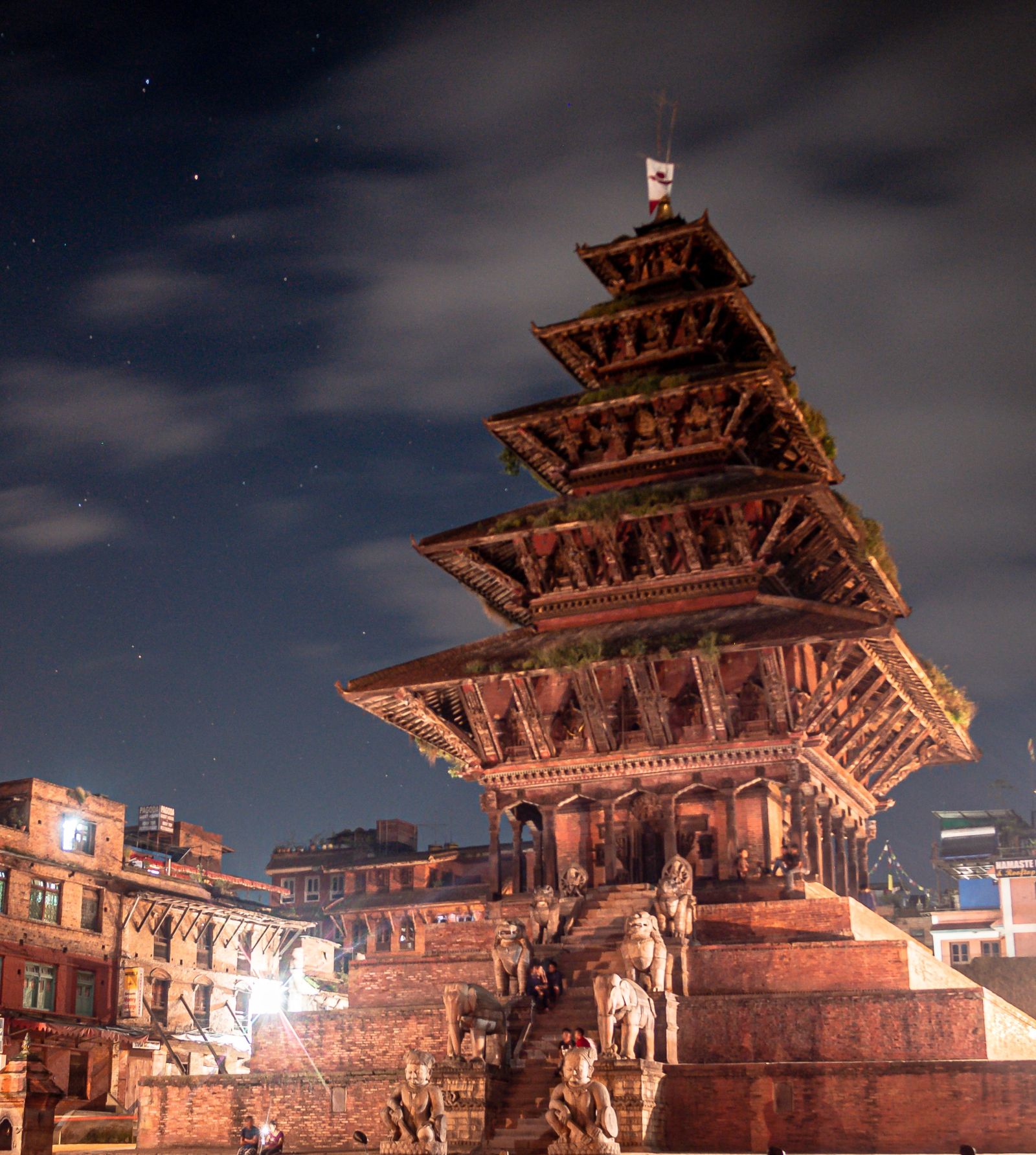 A traditional multi-tiered pagoda building under a starry night sky.