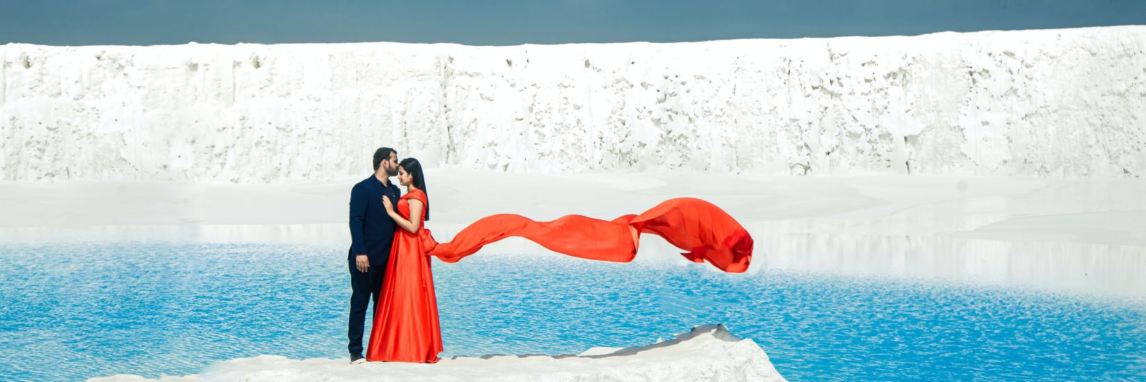 A couple posing for a picture in front of a glacier