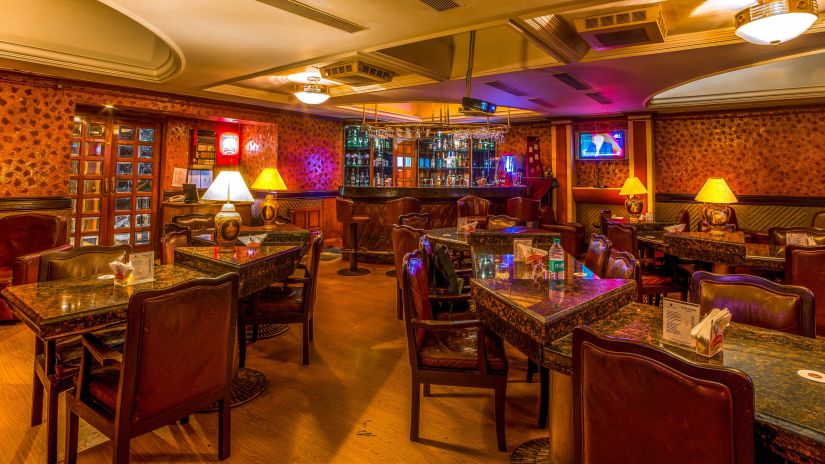 the seating area with the bar counter in the background at the Bar at Raj Park Hotel in Alwarpet, Chennai