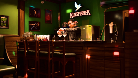 The bartender prepares drinks behind the counter