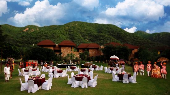 One of the open-air venues at Ananta spa & resort fully decked up with chairs, tables and a projector screen for events in pushkar  