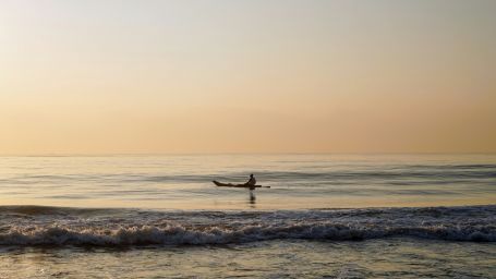 A person going on a boat in elliots beach in Chennai during the evening