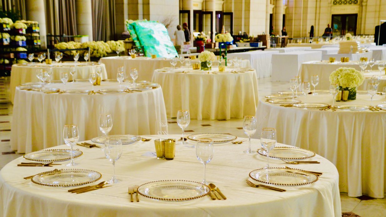 a banquet hall with tables and chairs decorated in beige colour for a party