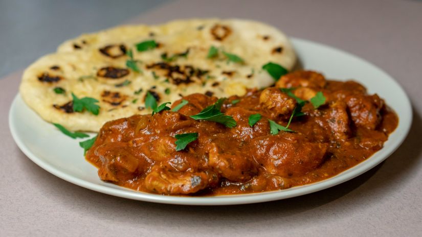 naan served with an indian curry on a plate