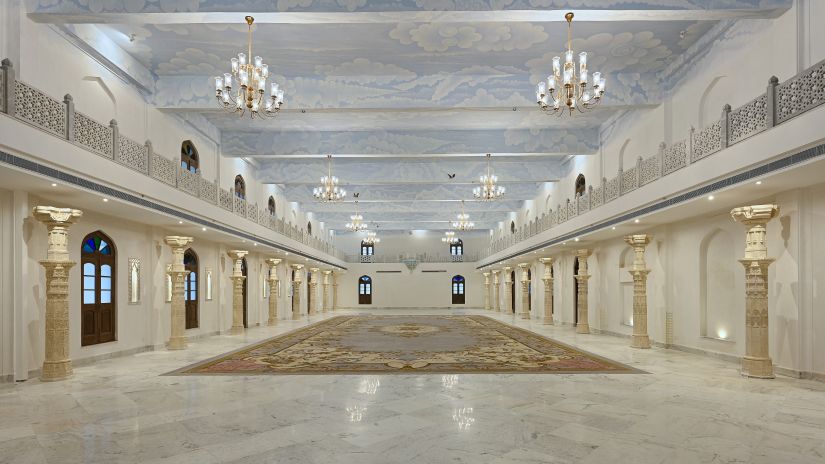 Fateh Vilas Udaipur - interior view of the Surya Prakash hall featuring white and cream decor with numerous chandeliers