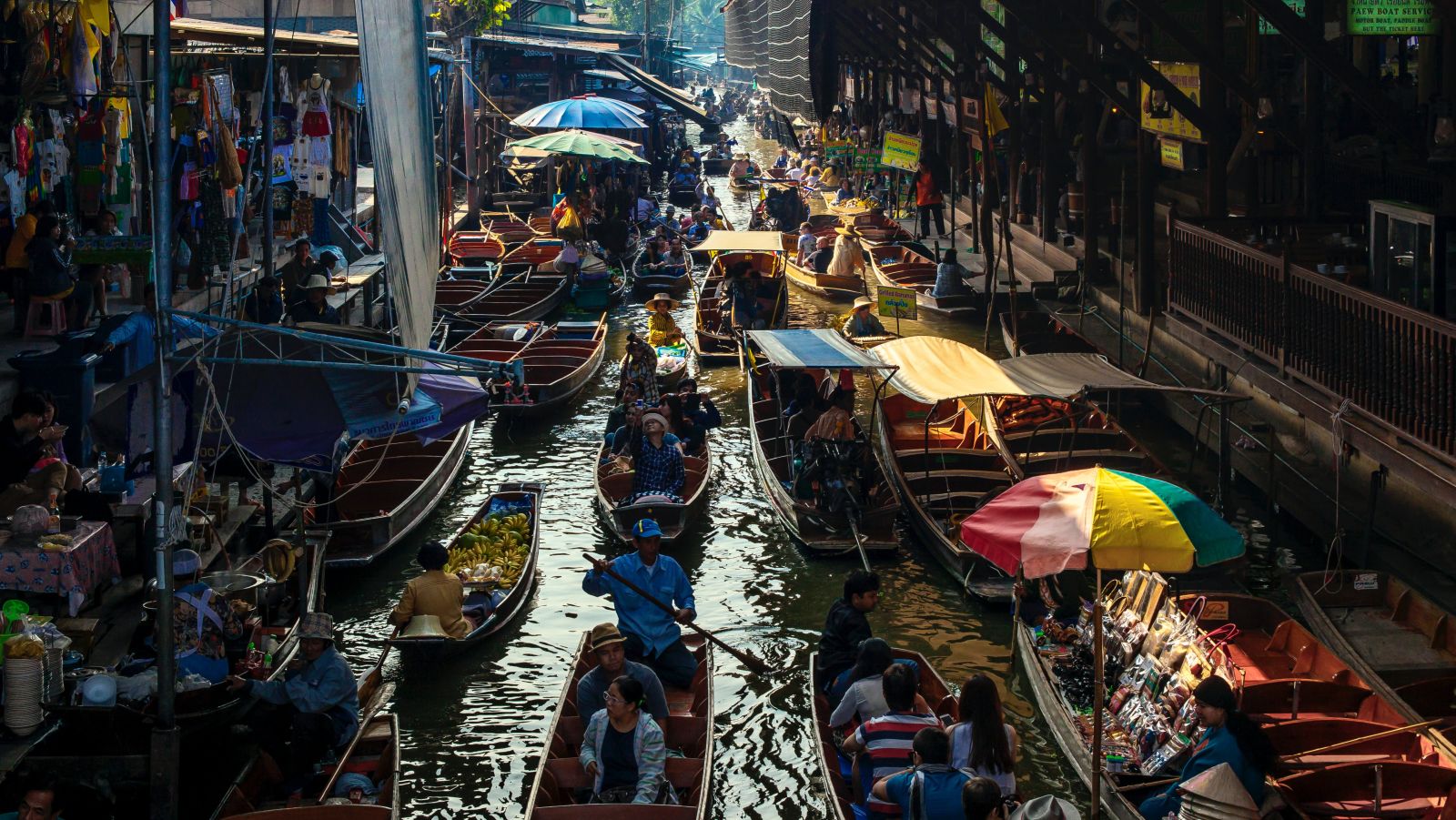 An overview of a floating market with people selling and buying things 