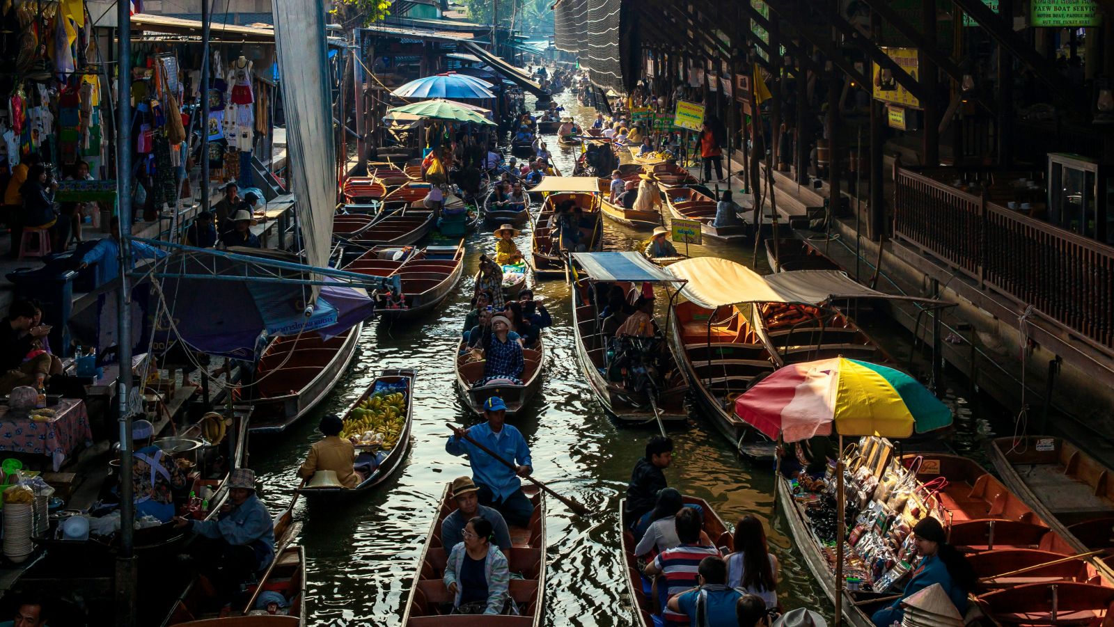 an overview of a floating market with different boats selling different things