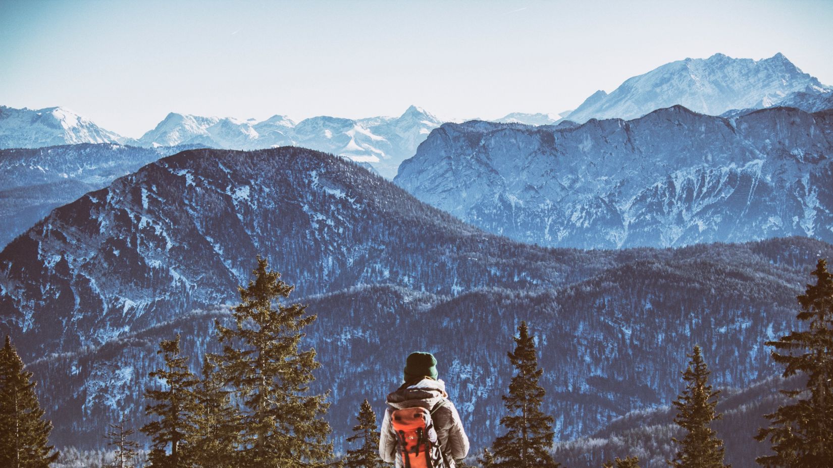 Man standing infront of snow capped mountains amidst the valley