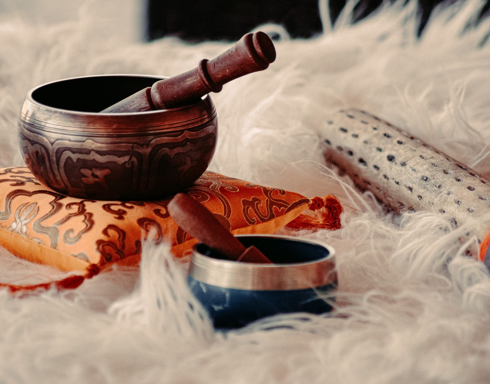 instruments used for sound therapy placed on a white fur cloth