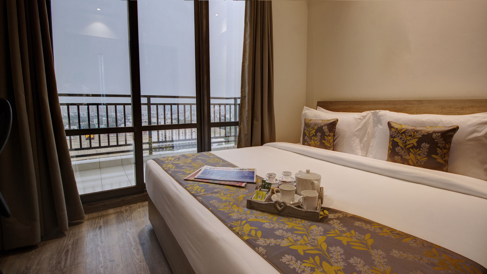 a king bed with pillows and bed runner inside the Two bedroom Executive Suite - Rhythm Gurugram