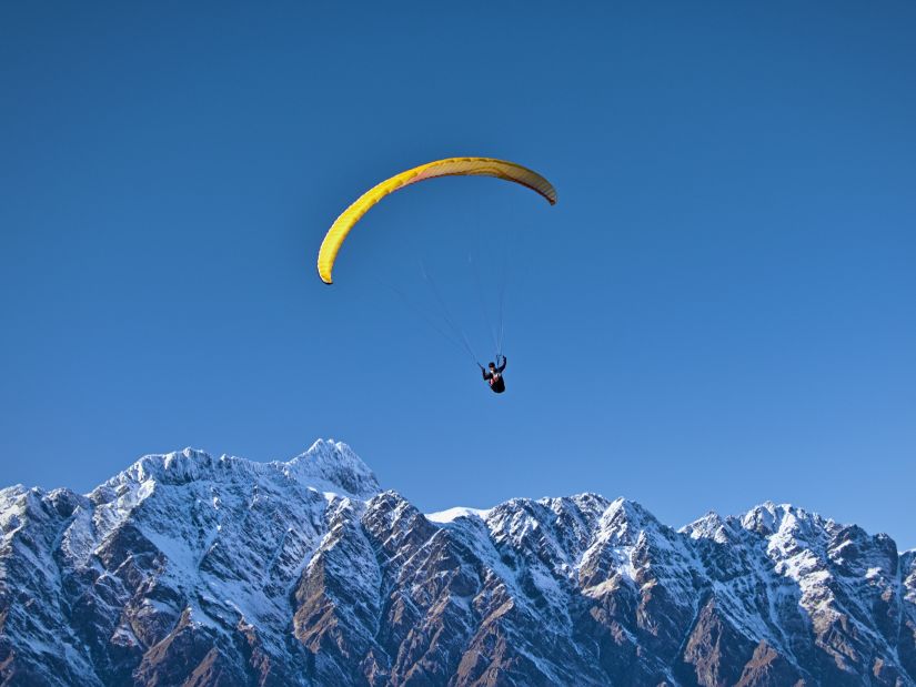 A man paragliding on top of the mountains - The Orchid Manali