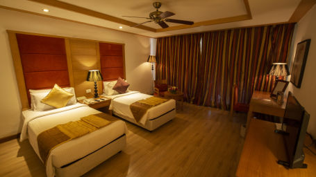 OS-FERNS room with twin beds and a TV at Ocean Spray Puducherry 