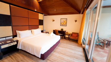Santorini Villa with a balcony, queen size bed and wooden headboard at Ocean Spray Puducherry