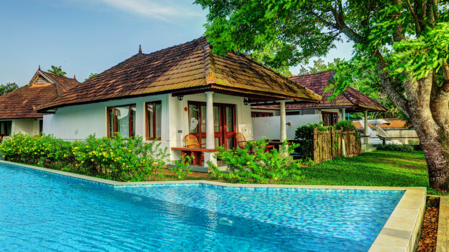 a swimming pool in front of the exterior of a room - Rhythm Kumarakom