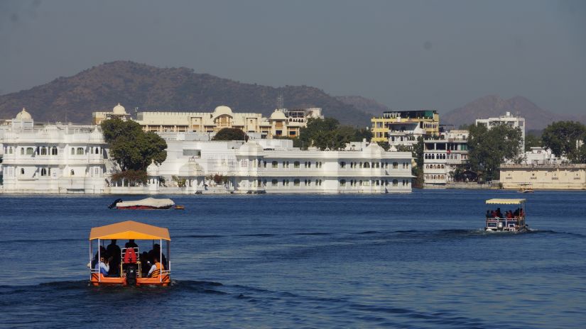 A boat taking passengers to a palace that is floating on a river