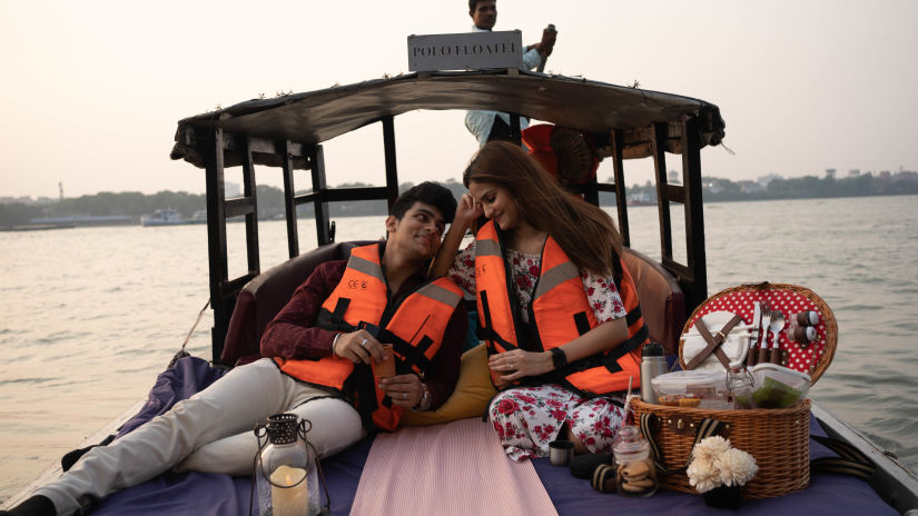 a couple with a picnic basket on a boat that is sailing on the ocean - Polo Floated Kolkata