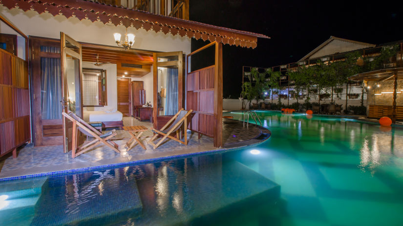 a swimming pool in from of Casa Aqua with chairs on the balcony - Symphony Summer Sand Beach Resort And Spa, Neil Island