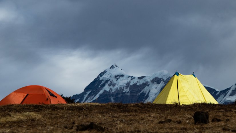 tents on a  hill with mountain in the background