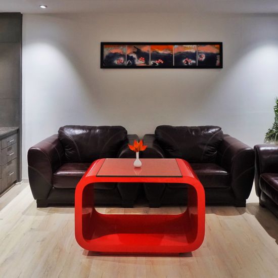 A front view of the living area of Suit with two brown couches and one red coffee table