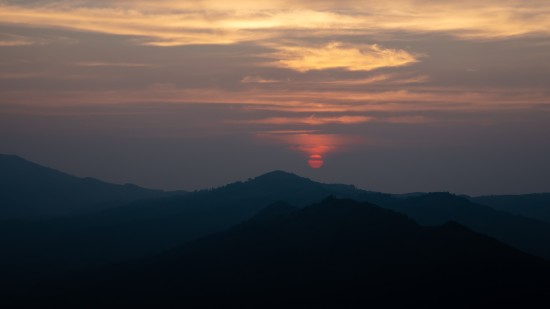 silhouette of a mountain peak during sunset with pink clouds in sky