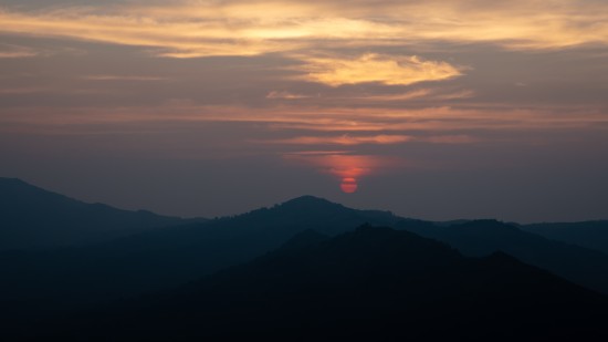 silhouette of a mountain peak during sunset with pink clouds in sky