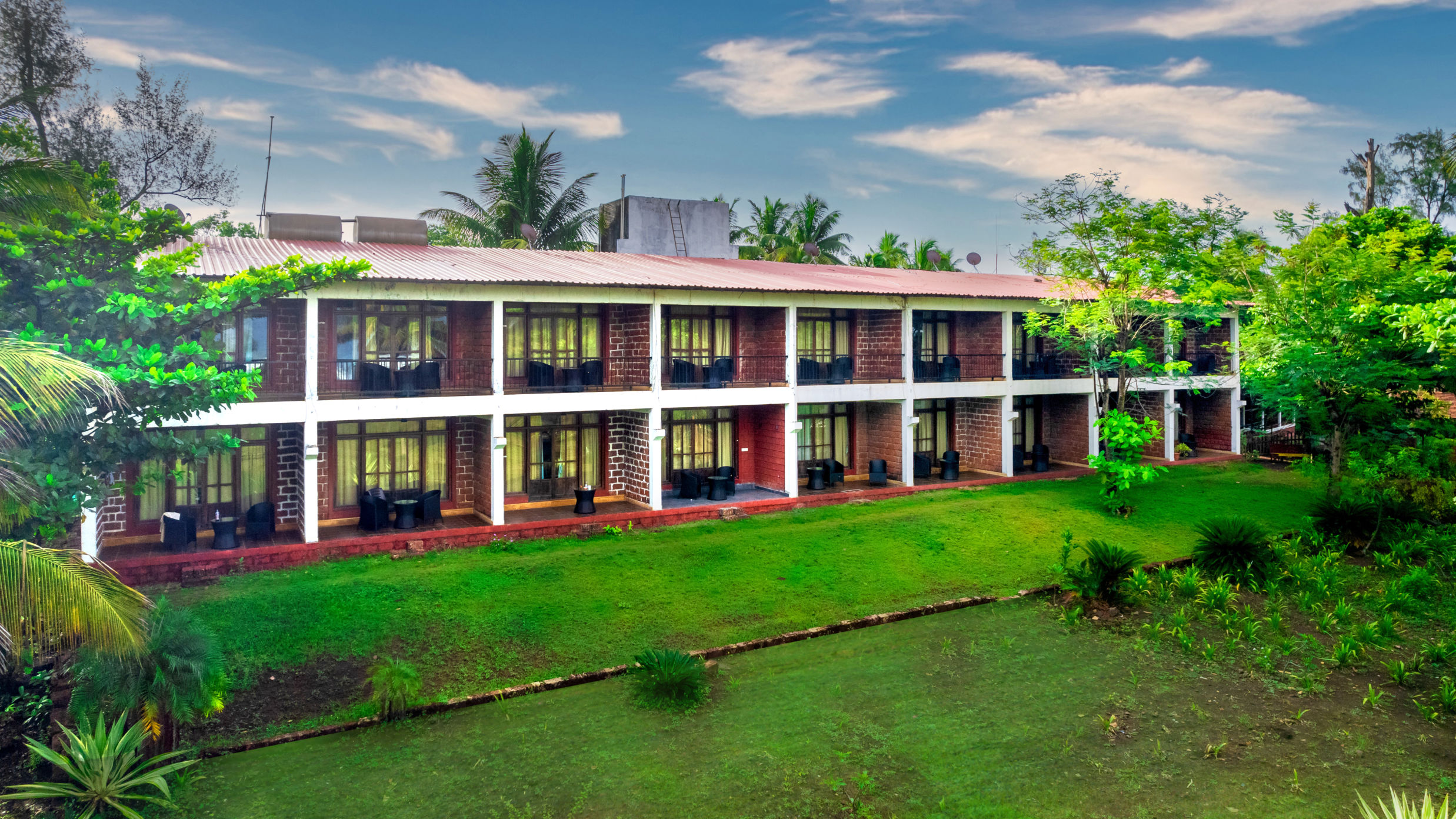 Lotus Eco Beach Resort Murud - exterior view of the property facade surrounded by lush greenery