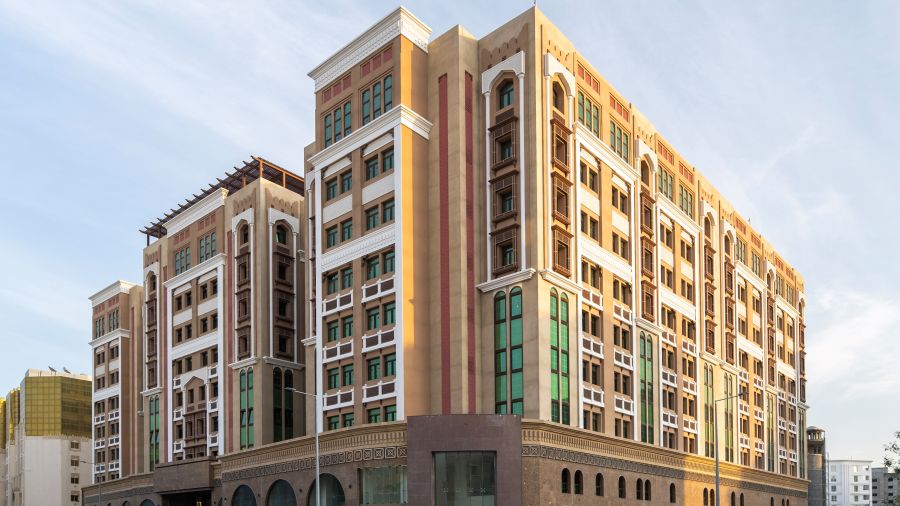 Facade image of La Maison Hotel, Doha with blue sky in the background