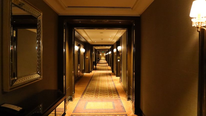 hallway of a hotel with the lights on leading to the many rooms