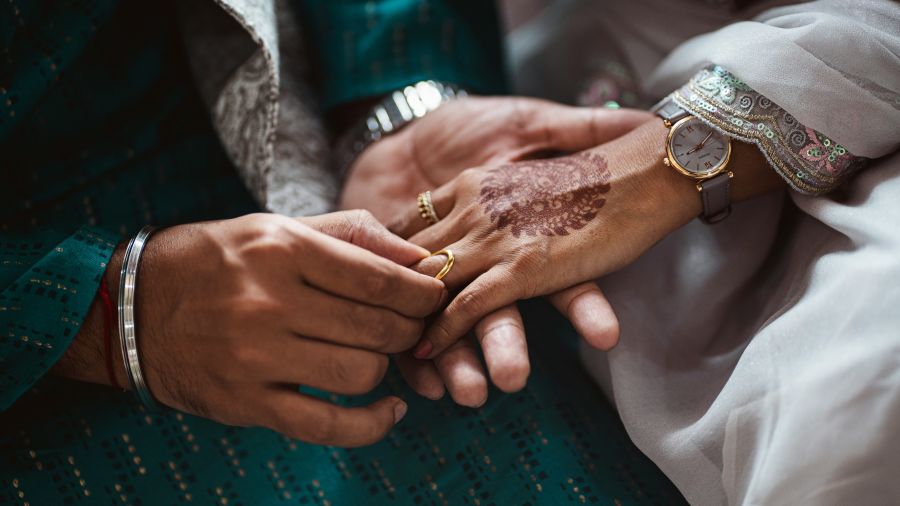 a close up shot of a couple exchanging rings on a ring ceremony