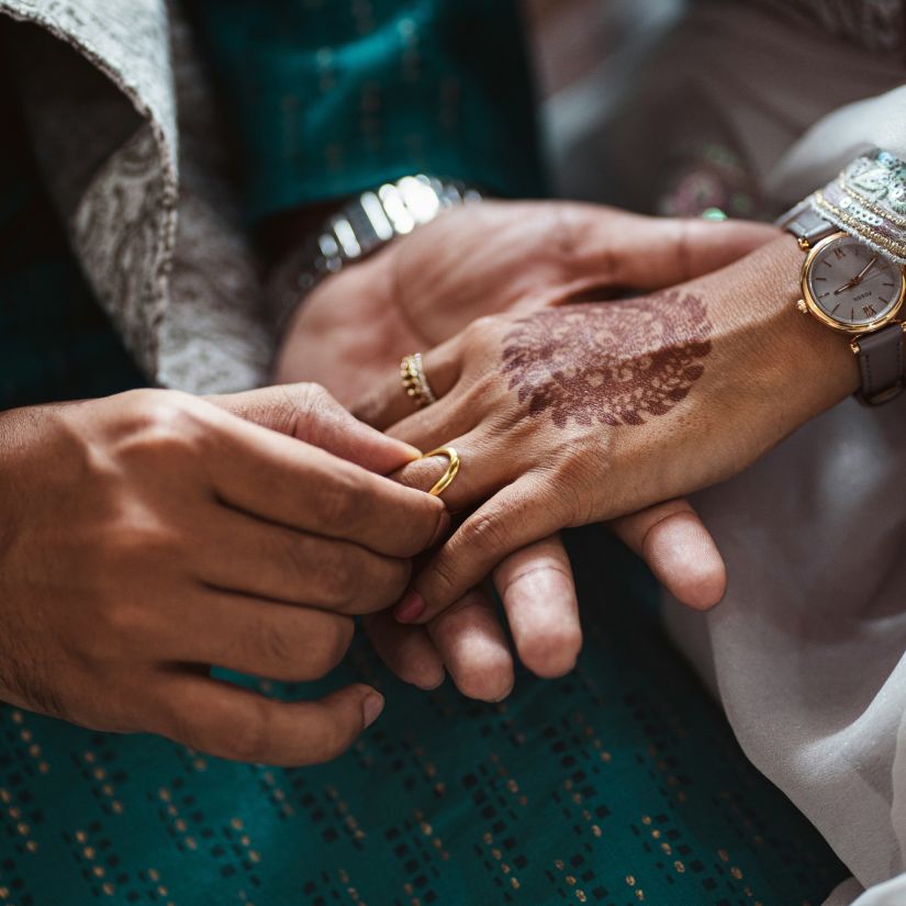 a close up shot of a couple exchanging rings on a ring ceremony