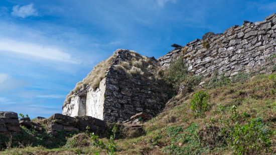 An old building in front of a fortified wall on a mountain in chikmagalur