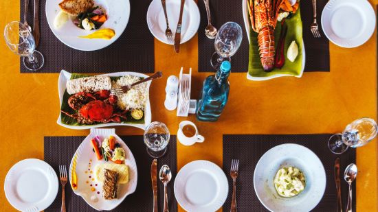 a table with 4 plates and different foods - Symphony Samudra Beachside Jungle Resort And Spa, Port Blair