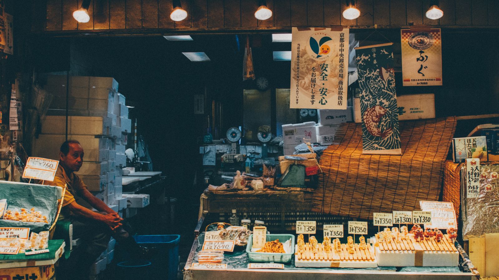 a person sitting and waiting for people to come and have food from his food stall