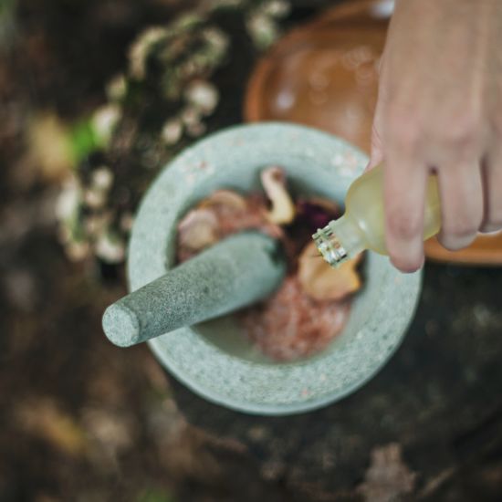 A head shot of ayurvedic herbs being crushed