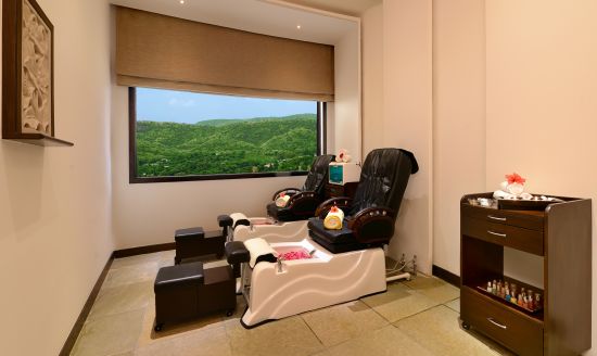 alt-text The pedicure section of Mudra spa with comfortable chairs, footbath and a window 4 o