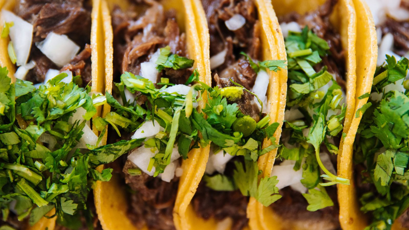 a taco served with meat and cilantro in it