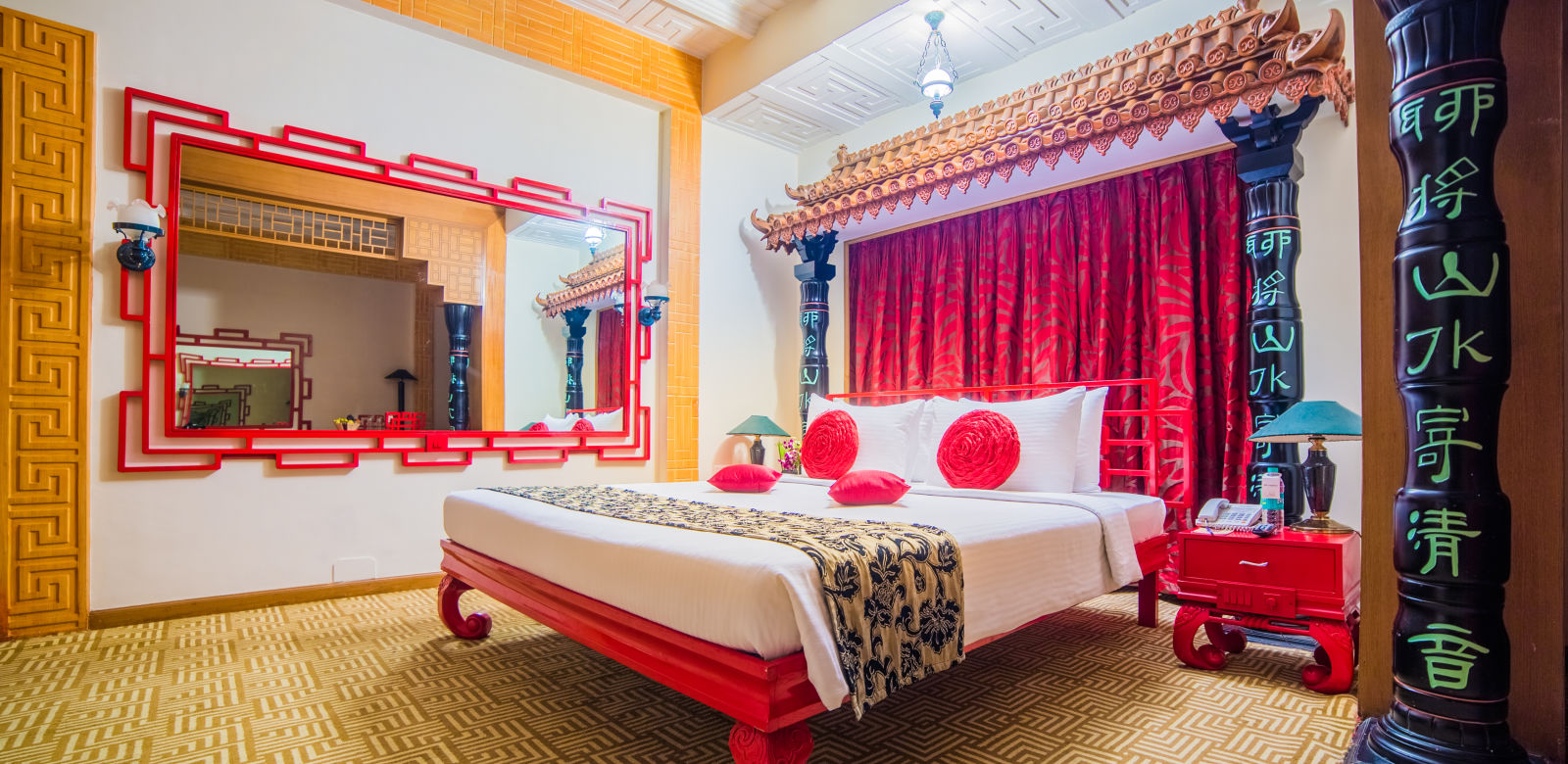 A vibrant hotel bedroom with a red and white color scheme, traditional decor, and a comfortable bed -Sitara - Luxury Hotel