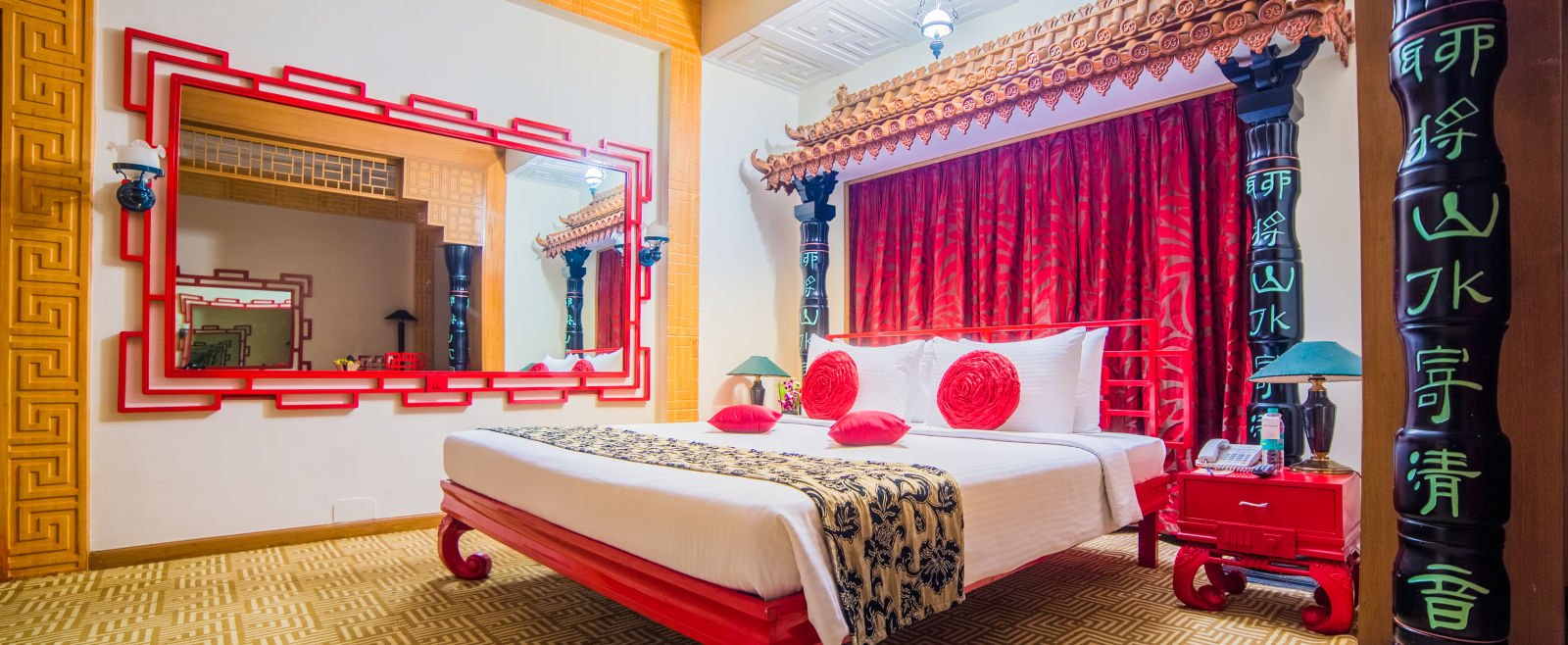 A vibrant hotel bedroom with a red and white color scheme, traditional decor, and a comfortable bed -Sitara - Luxury Hotel