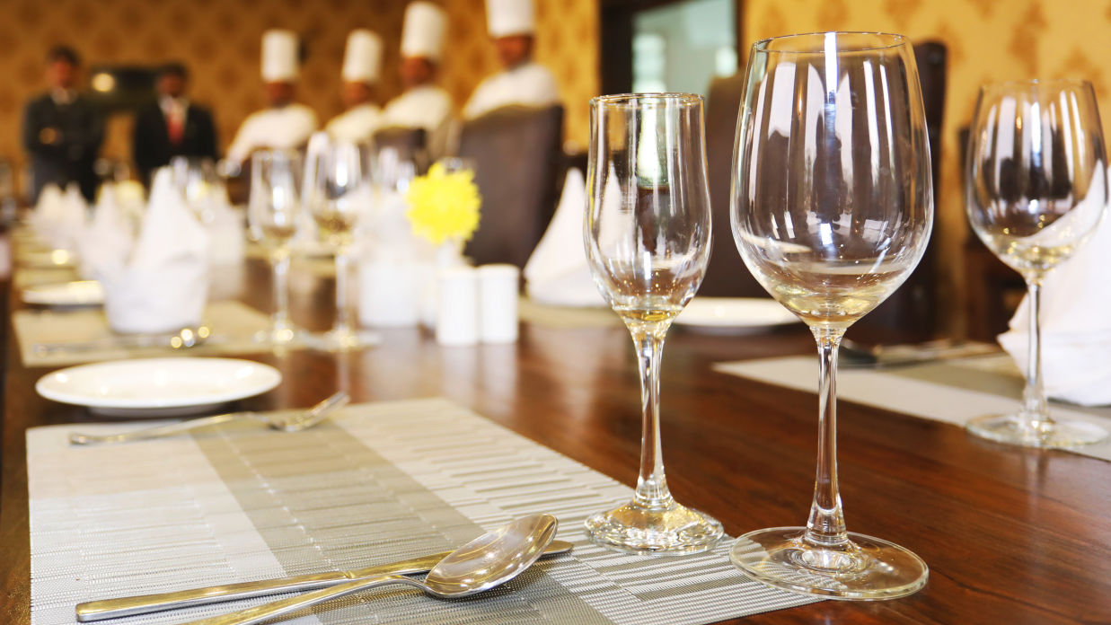 A restaurant image  featuring chefs in the background and wine glasses - Clarks Safari, Ranthambore