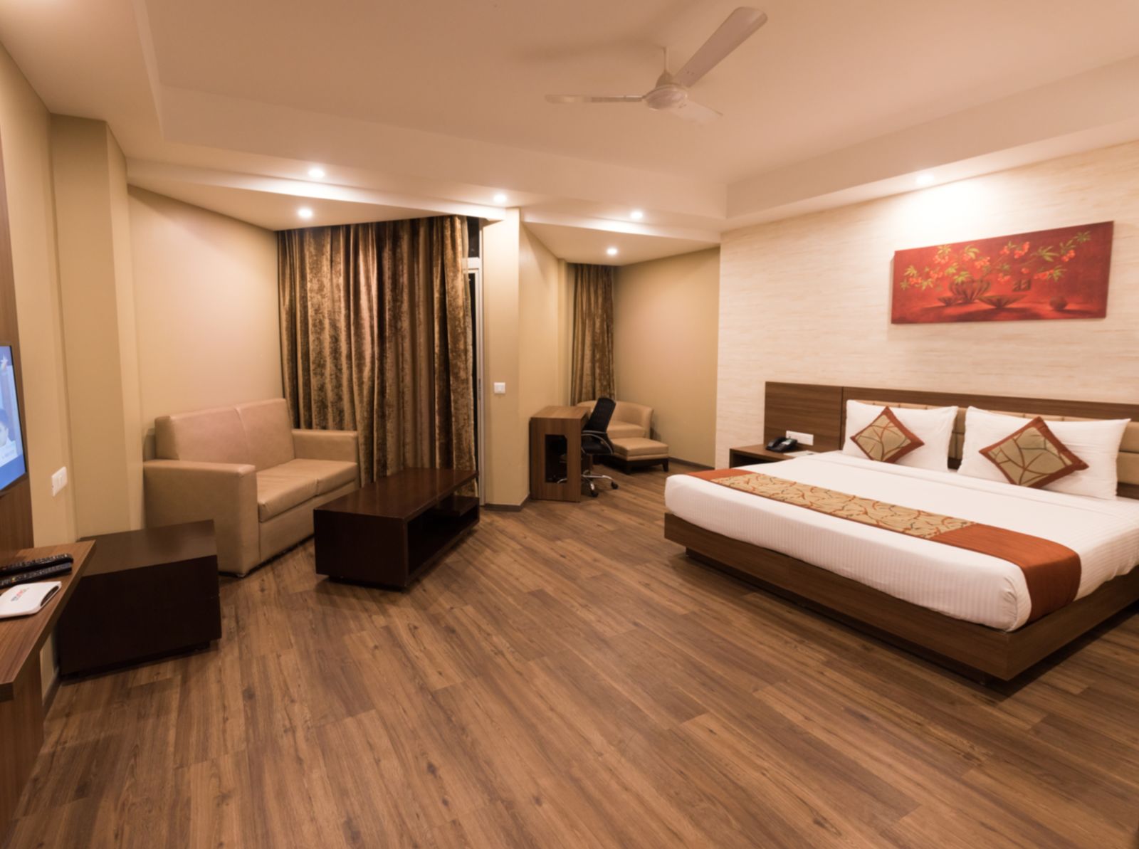 Super Deluxe Rooms with Complimentary Wi-Fi captured with a cosy bed and white linens along with a beige couch - Le ROI Digha Hotel West Bengal2