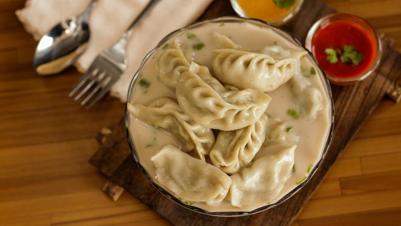 Hot steaming Momos served with red and yellow chutney