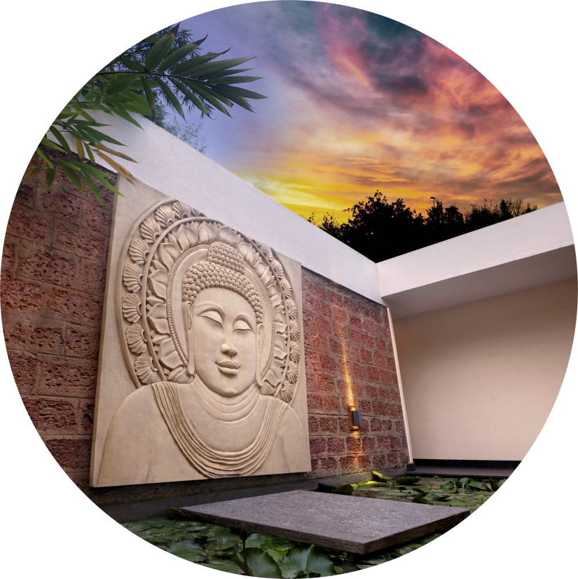 Artistic Buddha wall sculpture with ambient lighting in an outdoor setting.