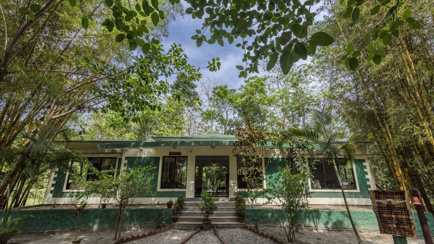 Exterior of the reception surrounded by trees at The Riverwood Forest Retreat, Dooars