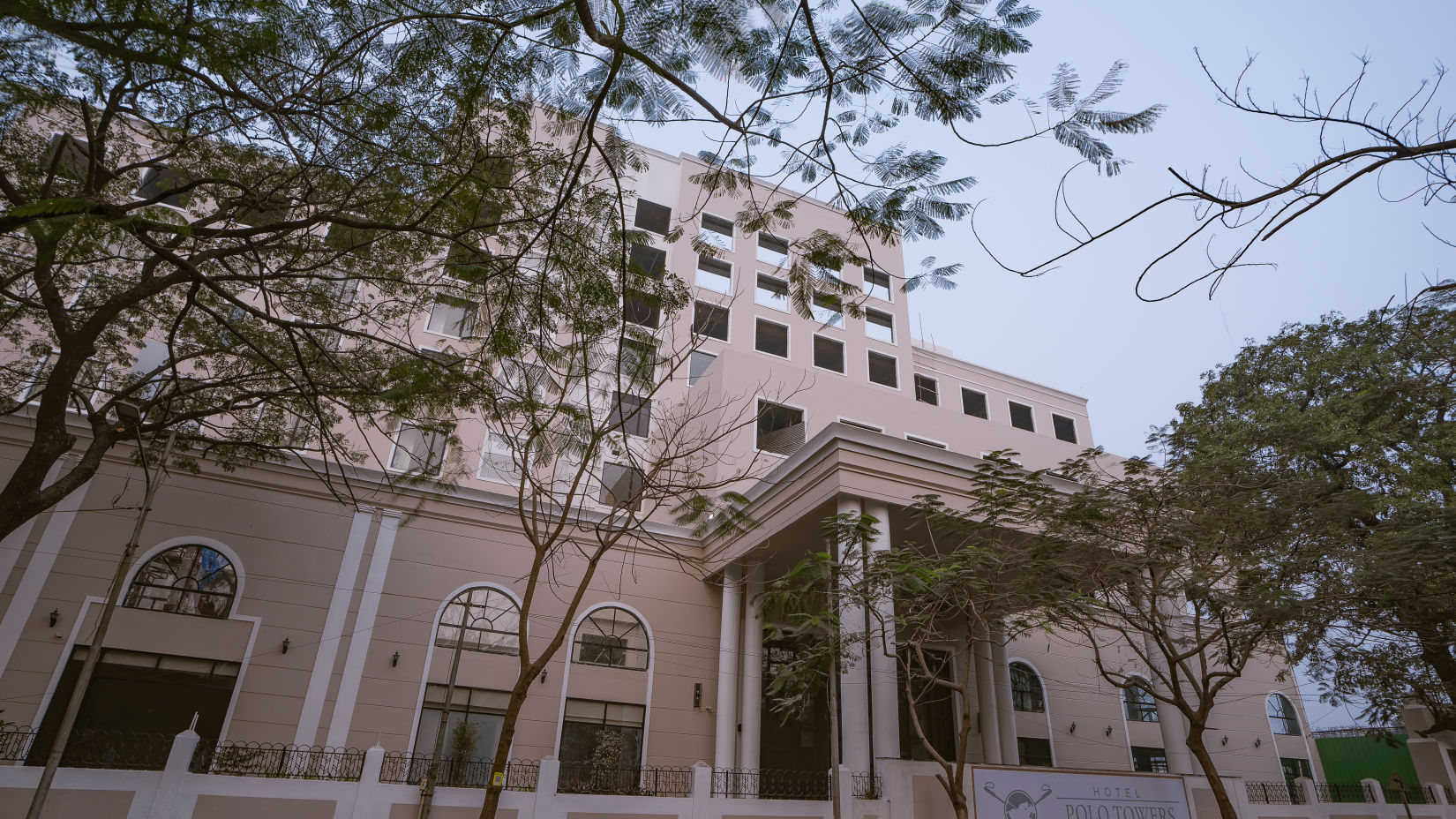 exterior facade of Hotel Polo Towers Agartala with trees covering the front side