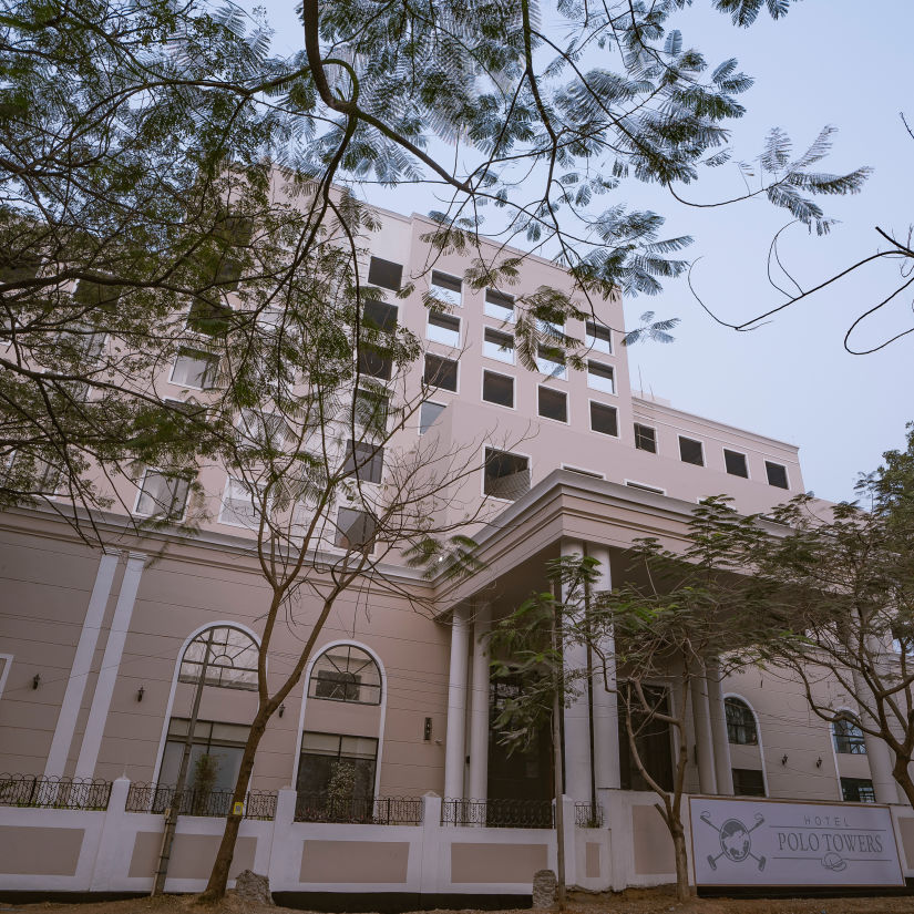 exterior facade of Hotel Polo Towers Agartala with trees covering the front side