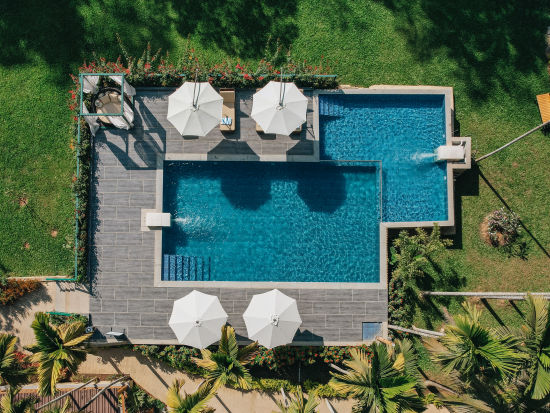 aerial view of the swimming pool with canopies open and garden surrounding it - Stone Wood Jungle Resort, Dandeli