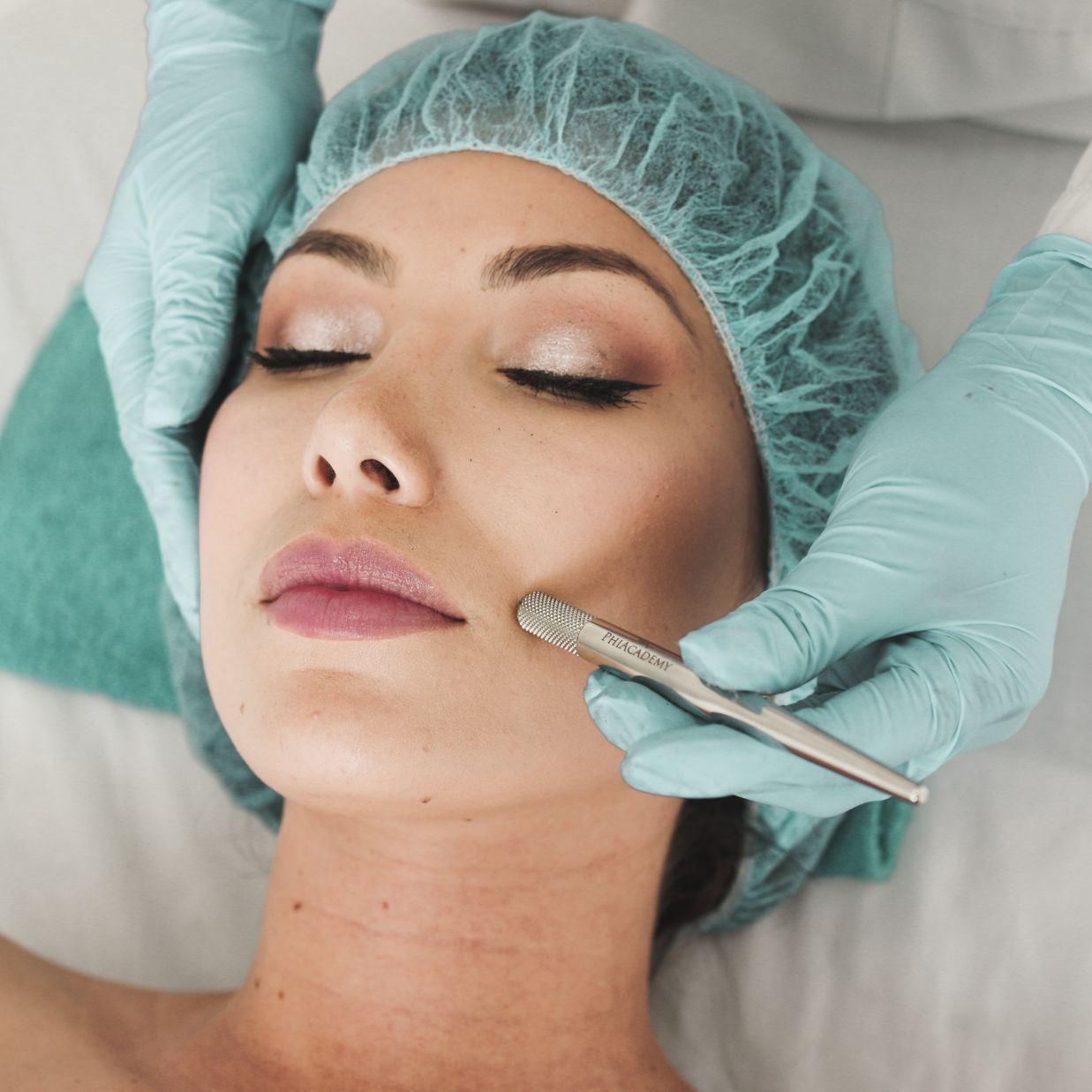 A woman receiving a facial massage from a therapist.